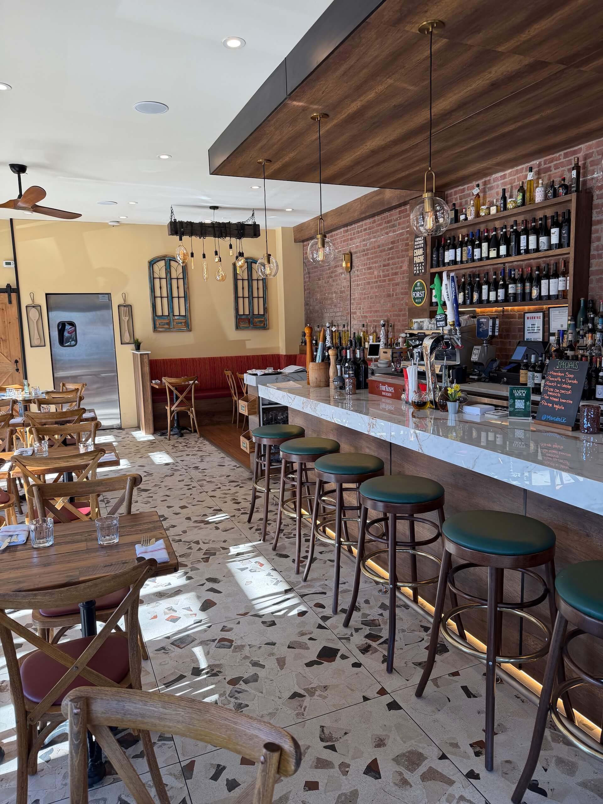 The long marble bar with green stools beside the dining room